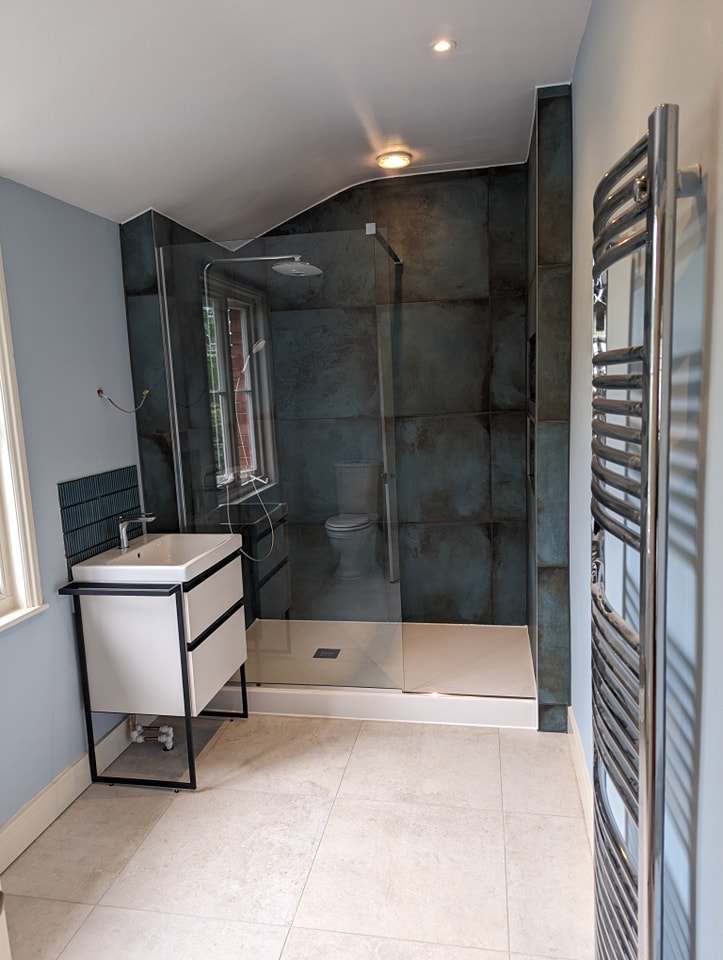 Modern bathroom refurbishment with grey tiling and chrome fixtures in Cheltenham